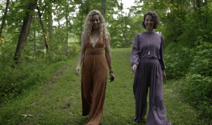 Two women walking a forest path at Munaya