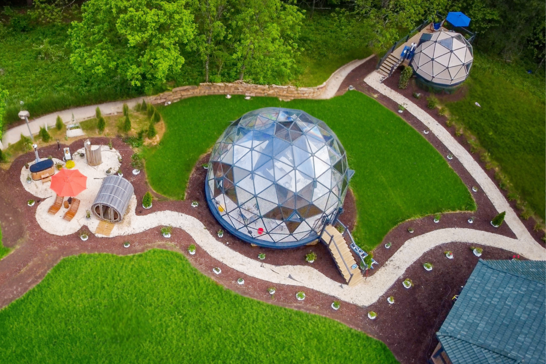 Aerial view of the glass geodesic dome and surrounding gardens at Munaya