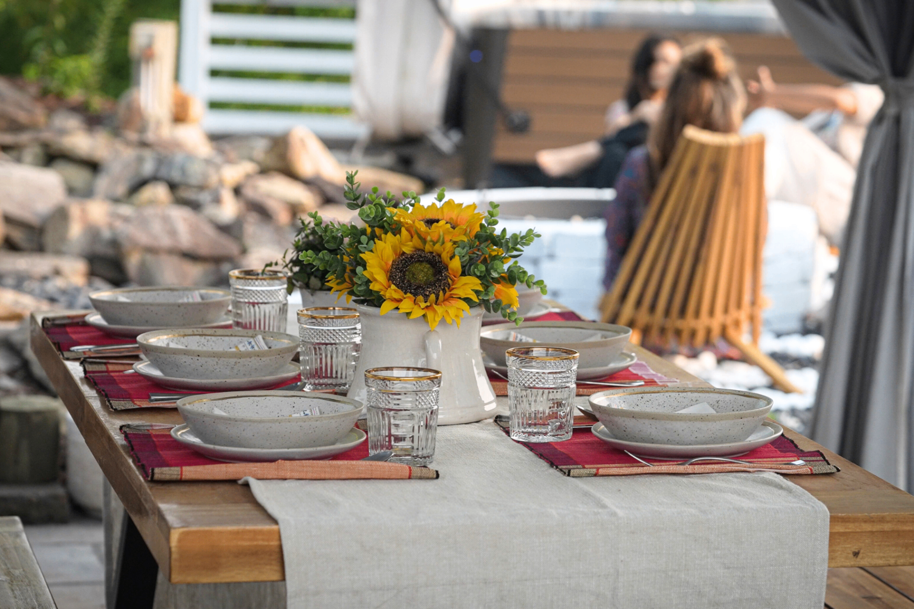 An outdoor table set with sunflowers outside the farmhouse