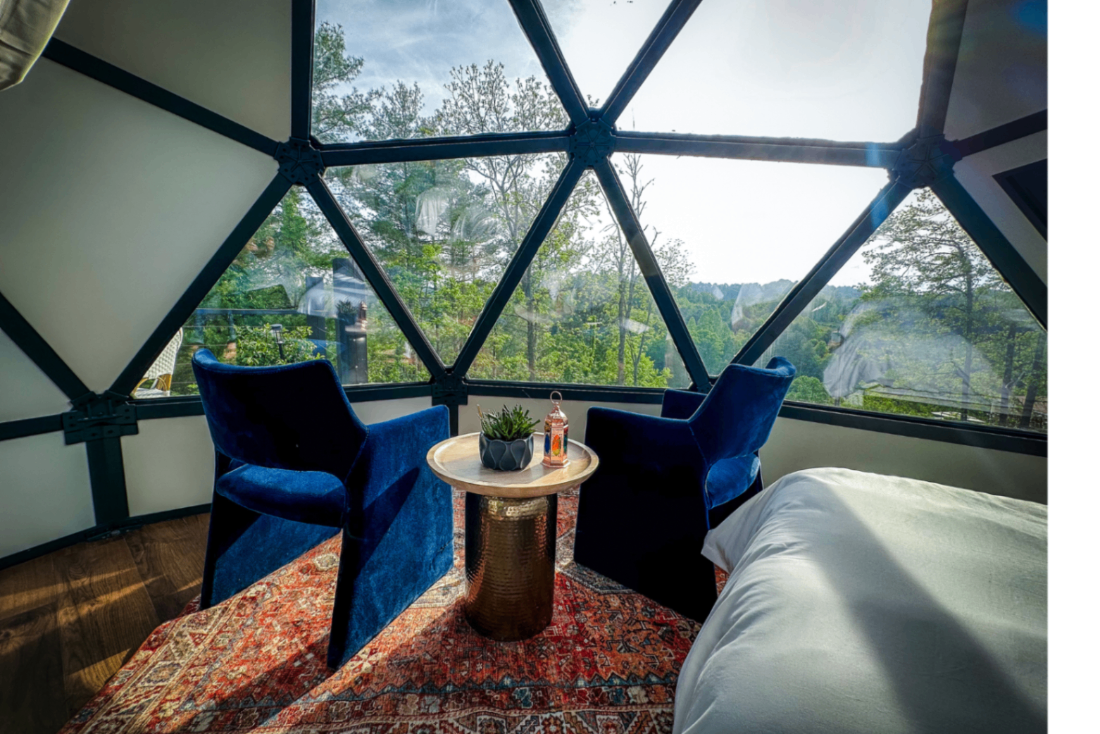 Casablanca dome interior with blue velvet chairs, Moroccan lantern, and Persian rug beneath the geodesic glass
