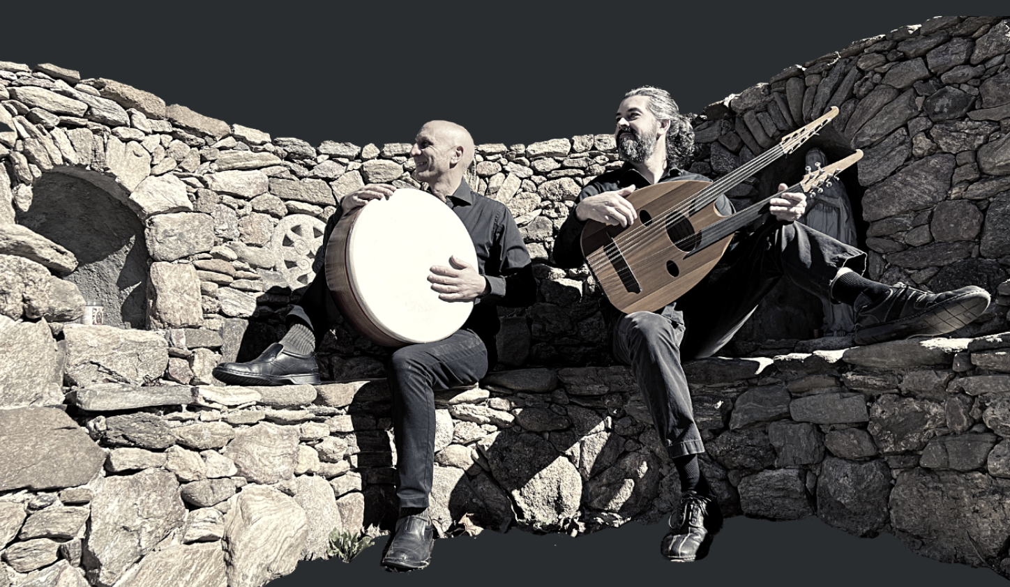 River and Chris of Free Planet Radio playing frame drum and oud on a stone wall