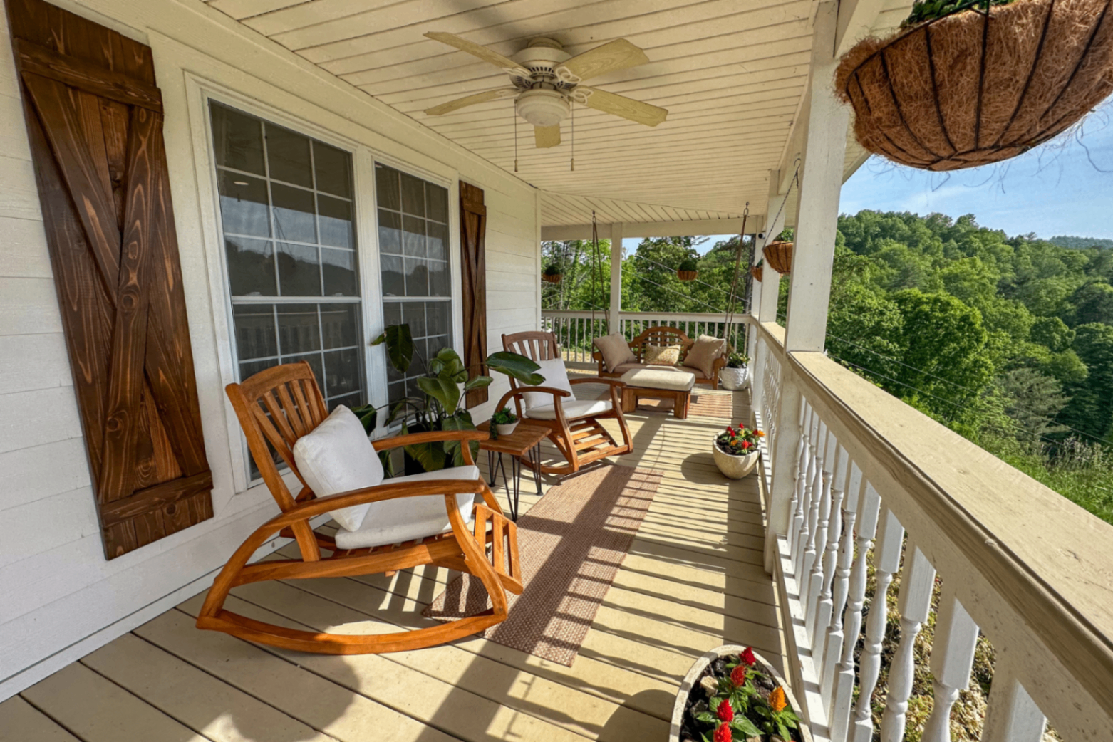 Rocking chairs lined up along the farmhouse porch in daylight