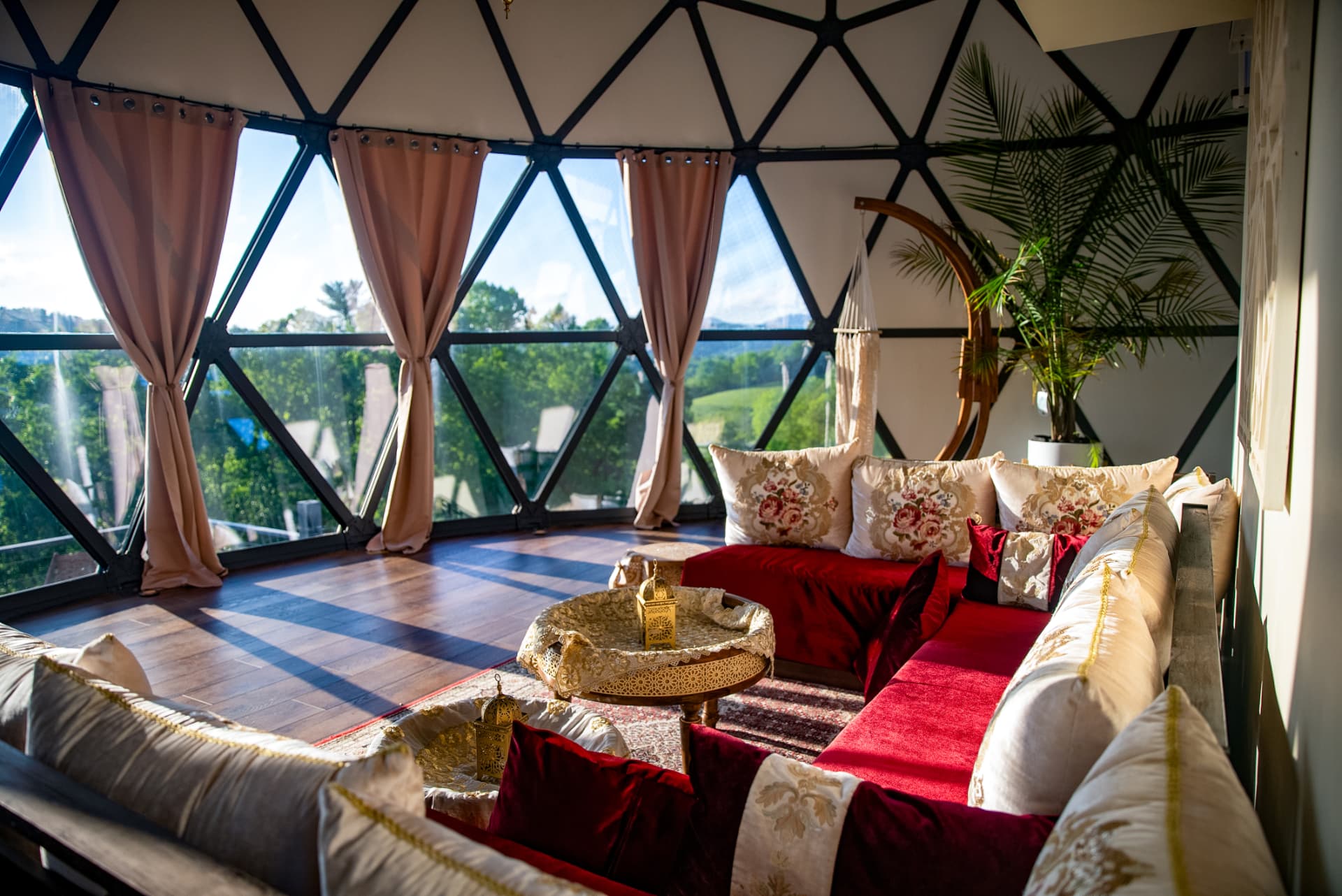 Moroccan seating in red and gold inside the Casablanca Dome, with mountain views through the glass panels