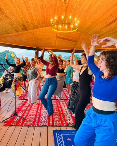 Guests dancing together with their arms raised beneath the pavilion
