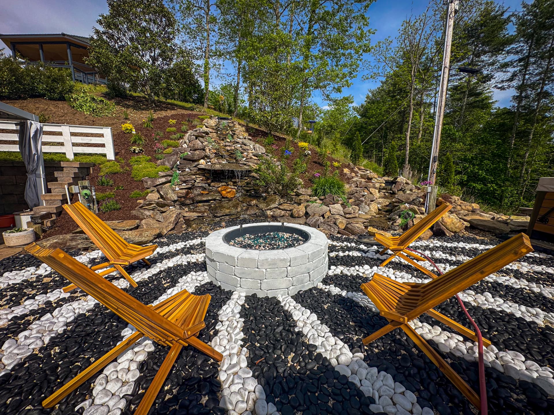 Stone waterfall garden beside the fire pit at Munaya Maison